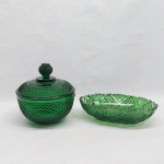 Duas peças em vidro verde: A) Bomboniere moldada no estilo ponta de diamante. Lascado na tampa. Med. 16 x 15 cm.  B) Travessa moldada com palmas e estrelas. Desgaste na pintura. Med. 22 x 13 cm.