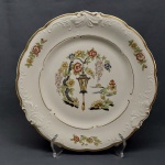 Prato decorativo em porcelana polonesa na cor branca, borda dourada recortada, moldada na pasta com volutas e acantos. Decorado com flores e motivos orientais. Marcado KPM. Diam. 27 cm.