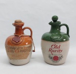 Duas garrafas para uísque em cerâmica esmaltada nas cores bege, marrom e verde. Alt. 21 cm.