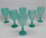 Seis taças para água em vidro verde satinê, base redonda haste com gomos e bojo liso. Alt. 19 cm.