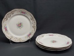 Quatro pratos rasos em porcelana polonesa na cor branca, borda movimentada decorada com linhas, volutas, acantos e grinaldas em douração, aplicada com flores e folhagens coloridas. Marcado KPM. Diam. 24 cm.