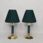 Par de castiçais em metal dourado, base em degraus, coluna octogonal na tonalidade verde. Cúpula em pergaminho verde. Alt. total 28,5cm.