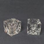 Par de castiçais em bloco de cristal no formato de cubo, lapidado com círculos. 6,5 x 6,5cm.
