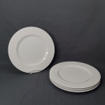 VISTA ALEGRE - Quatro sousplat em porcelana vitrificada branca portuguesa, modelo Perla, borda decorada com relevo perolado. Manufatura no fundo. Diâm. 32cm.