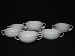 VISTA ALEGRE - Seis consumes com respectivos pires, porcelana portuguesa branca, borda moldada na pasta com trançados. Marca da Manufatura no fundo. Diam. do consume 12cm.