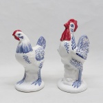 LUIZ SALVADOR - Duas estatuetas em cerâmica esmaltada, retratando galo e galinha. Adornadas em rica policromia . Marca da Manufatura no fundo. Alt. 18 e 15 cm.
