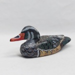 Pato selvagem esculpido em madeira policromada. Med. 12 x 25 cm.