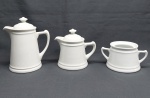 Três peças em porcelana branca: açucareiro (falta tampa), bule p/ chá e bule p/ café. Alt. 8 a 19 cm.