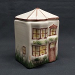 Biscoiteira em porcelana creme na forma de casarão.  Med. 15 x 10 x 10 cm.