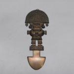 Ícone peruano em metal amarelo na forma de faca sacrificial representando sacerdote. Alt. 27 cm.
