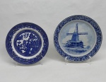 Dois pratos decorativos em porcelana azul e branca: A) Inglês, decorado com motivos orientais. Marcado WOODSWARE - ENGLAND. Diam. 23 cm. B) Holandês, pintado a mão com moinho, flores e acanto. Inscrição " PALTROKMOLEN". Diam. 26 cm.