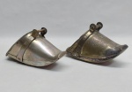 Dois estribos em metal prateado, um deles lavrado com flores e acantos. Alt. 10 e 11 cm.
