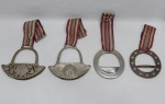 Quatro estribos decorativos em metal prateado e dourado. Dois redondos e dois com brasão da república (um deles desgastado). Alt. 13 e 16 cm.