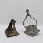 Dois estribos em metal dourado e prateado. Um deles vasado com rosas, folhagens, florão e tatus. Alt. 10 e 20 cm.