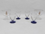 Seis copos em vidro translúcido: A)  Quatro p/ aperitivo, base redonda em vidro azulão. Alt. 7 cm. B) Duas taças para conhaque, decorada com veleiros em douração. Alt. 9 cm.