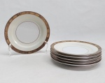 NORITAKE - Seis pratos para pão em porcelana japonesa decorada com faixa creme, borda em ouro brunhido e canetado em preto com flores e folhagens. Marca da Manufatura no fundo. Diam. 16cm.