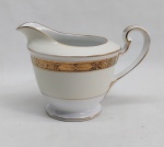 NORITAKE - Cremeira em porcelana japonesa decorada com faixa creme, borda em ouro brunhido e canetado em preto com flores e folhagens. Marca da Manufatura no fundo. Alt. 10cm.