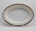 NORITAKE - Grande travessa em porcelana japonesa decorada com faixa creme, borda em ouro brunhido e canetado em preto com flores e folhagens. Marca da Manufatura no fundo. 41 x 31cm.