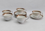 NORITAKE - Cinco xícaras para chá com respectivos pires, porcelana japonesa decorada com faixa creme, borda em ouro brunhido e canetado em preto com flores e folhagens. Marca da Manufatura no fundo.