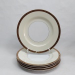 NORITAKE - Cinco pratos rasos em porcelana japonesa decorada com faixa creme, borda em ouro brunhido e canetado em preto com flores e folhagens. Marca da Manufatura no fundo. Um com quebrado e colado na borda. Diam. 20cm.