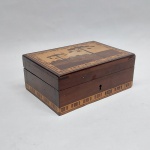 Caixinha em madeira marchetada com araucárias, com fechadura, faltam a chave. Med. 5 x 9 x 13 cm.