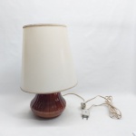 Abajur em porcelana em porcelana esmaltada na cor marrom, bojo moldado com gomos. Cúpula plástica. Alt. 41 cm.