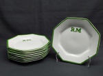 Oito pratos oitavados p/ sobremesa em porcelana branca, borda verde. Decorados com as iniciais RM. Marcado SCHMIDT. Diam. 20 cm.