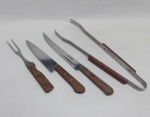Serviço p/ churrasco (diversas procedências): garfo, faca, faca p/pão e pegador (4 peças). Cabos em madeira. Med. 26 a 37 cm.