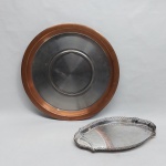 Duas peças em cobre e metal prateado: A) Salva guarnecida com elipses na borda. Med. 30 x 18 cm. B) Bandeja redonda com borda cobreada. Diam. 35 cm.