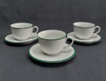 Três xícaras e pires p/ chá em porcelana branca, bordas decoradas com faixa verde. Duas xícaras com lascados na borda. Marcada GERMER.
