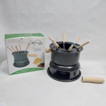 Aparelho p/ fondue em metal revestido de material antiaderente, pegas em madeira. Acompanha sete garfinhos e dois queimadores. Alt. 17 cm.