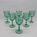 Seis taças p/ vinho tinto em vidro verde, base redonda, haste balaustre e bojo moldado no padrão dedão. Alt. 15 cm.