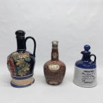 Três garrafas em cerâmica esmaltada, decorações diversas. Maior com a base colada. Alt. 20 a 27 cm.