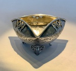 Covilhete em prata de lei. Delicado covilhete em prata de lei (833), de formato triangular com lados suavemente abaulados e bordas recortadas em leve elevação. Repousa sobre três pés vazados de inspiração rococó, com decoração repuxada e cinzelada de acantos e volutas estilizadas que se repetem na borda e no interior da peça, emoldurando reservas lisas. Peça de excelente acabamento, marcada PRATA 833, com punção parcial de oficina (não identificada). Trabalho português ou brasileiro de boa fatura, século XX.Medidas: 12,5 cm x 12,5 cm x 12,5 cm (formato triangular).Altura: 6 cm.Peso: 136 g.Material: Prata de lei (833).Procedência: Acervo família Rezende  residência Av. Atlântica, Copacabana  Rio de Janeiro.