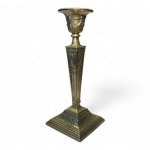 PRATA INGLESACastiçal estilo Neoclássico Georgiano, confeccionado em prata de lei marcada (punções parciais desgastadas, possivelmente Sheffield, teor 925), decorado em toda a superfície com guirlandas, laços e acantos em relevo. Corpo em peça única de fuste quadrangular afilado, base moldurada e campânula com borda perlada.Medidas: 31 cm de altura; base 12,5  12,5 cm.Peso bruto: 894 gramas.Estado: excelente, leve patina do tempo. 2/4