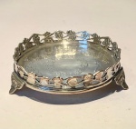 PRATA DE LEIPequena salva tripoide em prata de lei (teor verificado superior a 800), corpo circular com decoração rendilhada e fundo gravado com guirlanda floral central. Bordas recortadas com flores alternadas e três pés triangulares ornados com flor-de-lis.Medidas: diâmetro 10,5 cm  altura 3 cm.Peso bruto: 120 gramas. Estado: muito bom, leve pátina do tempo e discretas marcas de uso.