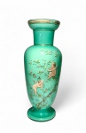 OPALINA FRANCESA - Grande vaso em vidro opalino com decoração esmaltada de putti entre ramagens floridas.Elegante vaso em vidro opalinado na cor verde jade, com delicada decoração policromada e dourada representando putti alados em travessuras entre ramos floridos e insetos. Bordas e base com frisos realçados a ouro. Peça de grande presença visual, típica da produção centro-europeia de fins do século XIX, com afinidade estilística às manufaturas de Boêmia e França (Saint-Louis e Baccarat), no período de transição entre o Romantismo e o Art Nouveau.Medidas: 37,5 cm de altura x 14 cm de diâmetro.Observação: pequena perda na Douração (vide fotos). Nota histórica:A opalina  vidro leitoso, translúcido e finamente colorido  tornou-se um símbolo de luxo burguês entre 1830 e 1900, especialmente em Paris e Murano. Vasos como este, com putti e flores, evocavam o universo mitológico e sentimental tão apreciado nos interiores vitorianos, sendo frequentemente exibidos sobre consoles ou buffets, como emblemas de gosto e prosperidade doméstica. Faz par com o lote seguinte
