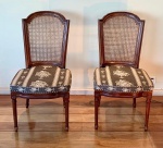 Par de cadeiras estilo Luís XVI em madeira nobre escurecida, manufatura não identificada, meados do século XX. Estrutura em madeira nobre escurecida, com encosto emoldurado em formato reto com coroa superior em semi-círculo de degrau duplo, característico do estilo Luís XVI.Encosto em palhinha indiana natural, original e bem tensionada.Assento solto, forrado em tecido sintético com padronagem clássica em preto e bege, simulando trama de palha natural.As pernas são retas e caneladas, unidas por travessas discretas, apresentando rosetas florais esculpidas nos cantos dos apoios frontais  detalhe distintivo da linguagem neoclássica francesa.Medidas: 100 cm de altura x 53 cm de largura x 55 cm de profundidade.Em bom estado geral de conservação, sem indícios de restauro, colagens, rachaduras ou partes substituídas.Necessitam apenas de leve lustro de realce para devolver brilho à madeira. Faz conjunto com os dois lotes seguintes.