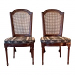 Par de cadeiras estilo Luís XVI em madeira nobre escurecida, manufatura não identificada, meados do século XX. Estrutura em madeira nobre escurecida, com encosto emoldurado em formato reto com coroa superior em semi-círculo de degrau duplo, característico do estilo Luís XVI.Encosto em palhinha indiana natural, original e bem tensionada.Assento solto, forrado em tecido sintético com padronagem clássica em preto e bege, simulando trama de palha natural.As pernas são retas e caneladas, unidas por travessas discretas, apresentando rosetas florais esculpidas nos cantos dos apoios frontais  detalhe distintivo da linguagem neoclássica francesa.Medidas: 100 cm de altura x 53 cm de largura x 55 cm de profundidade.Em bom estado geral de conservação, sem indícios de restauro, colagens, rachaduras ou partes substituídas.Necessitam apenas de leve lustro de realce para devolver brilho à madeira. Faz conjunto com os dois lotes anteriores.