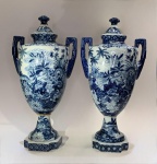 CERÂMICA ORIENTAL - Par de potiches orientais vitrificados. China, meados do século XXCerâmica vitrificada com decoração em azul cobalto sob o vidrado (blue and white), com tampas destacáveis e alças geométricas laterais. As peças apresentam corpo em forma de urna clássica apoiado sobre base octogonal, com pintura densa de paisagem naturalista em estilo oriental: aves entre flores, bambus e folhagens exuberantes, evocando o motivo tradicional de jardim de felicidade (Hundred Flowers).Sob a base, marca apócrifa de caráter decorativo em azul.Altura: 44 cm. Largura máxima (alças): 21 cm.Nota do editor. Este par traduz a permanência do gosto ocidental pelo exotismo chinês, ecoando os modelos do período Qing reinterpretados para o mercado decorativo do século XX. O azul profundo, de densidade irregular, revela técnica de aplicação manual sob vidrado, com traços vigorosos e detalhamento de grande efeito visual. O conjunto mantém elegância equilibrada entre a forma neoclássica e o repertório decorativo tradicional do Oriente.
