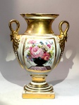 PORCELANA EUROPEIA -  Vaso decorativo / Limoges, FrançaAssinado Massou 1813. Porcelana fina francesa moldada e pintada à mão, corpo ovóide sobre base quadrada, alças modeladas em forma de cabeças de cisne e acabamento integral em douração de alto brilho.Painéis frontais e posteriores com reservas florais policromadas, enquadradas por filetes dourados.Marca em verde sob o vidrado: LIMOGES  Made in France.Medidas: 24,5 cm de altura x 18 cm de largura x 8 cm de espessura.Exemplar inspirado nos vasos Empire de Sèvres, típico das produções de Limoges do fim do século XIX e início do XX, com decoração em estilo neoclássico e assinatura alusiva a Massou 1813  em referência comemorativa de modelos originais do período napoleônico.Condição: douração com leves desgastes coerentes à idade. Faz par com o lote seguinte.