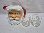 Lote natalino composto de jarra em porcelana e 2 copos em vidro. Medindo a jarra 14cm x 15cm de altura, copo 8cm x 8cm de altura.