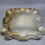 METAL - Bandeja quadrada em metal espessurada a prata, fundo lavrado e borda recortada. Med. 39x39 cm.