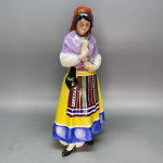 VISTA ALEGRE - Linda garrafa licoreira em fina porcelana, formato de mulher trajada com roupas típicas de Portugal, da tradicional fábrica VISTA ALEGRE. Alt. 28 cm.