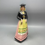 VISTA ALEGRE - Linda garrafa licoreira em fina porcelana, formato de mulher trajada com roupas típicas de Portugal, da tradicional fábrica VISTA ALEGRE. Alt. 27,5 cm. Tampa colada.