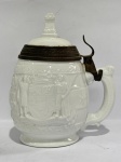 PORCELANA - Lindo tankard em porcelana branca, decorada em relevo, borda em metal. Alt. 18 cm.