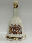 PORCELANA - Garrafa de whisky Bell´s Scotch, 750 ml, 1981. Comemorativa do casamento da Lady Di e Príncipe Charles, tampa de plástico, desgastes na douração. Alt. 25 cm. VAZIA.