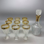 DEMI CRISTAL - Licoreira e 9 taças em demi cristal incolor, decorado com detalhes dourados. Med. 30 cm e 15 cm.