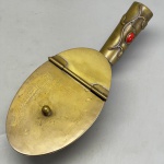 METAL - Lindo cata migalhas em metal dourado, oval, com aplicação de coral na alça . Med. 7x22x9 cm.