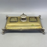 METAL - Antiga base tinteiro em metal espessurado a prata, com as iniciais L. E. F., datado de 26/7/922. Med. 9x25x16 cm. Marcas do tempo e de uso.